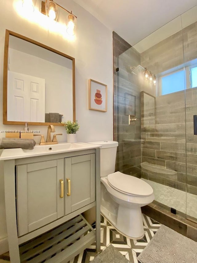 bathroom featuring vanity, a shower with shower door, and toilet