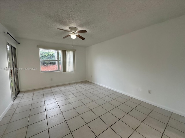 tiled empty room with a textured ceiling and ceiling fan