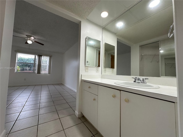 bathroom with tile patterned flooring, ceiling fan, a textured ceiling, and vanity