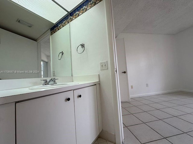 bathroom featuring tile patterned floors, vanity, and a textured ceiling