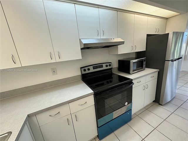 kitchen featuring white cabinets, light tile patterned flooring, and stainless steel appliances