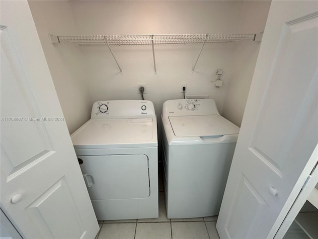 clothes washing area featuring light tile patterned flooring and independent washer and dryer