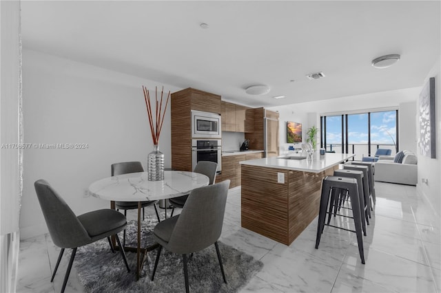 kitchen featuring sink, an island with sink, and stainless steel appliances