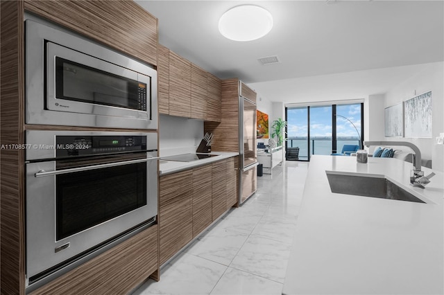 kitchen featuring stainless steel appliances, a water view, and sink