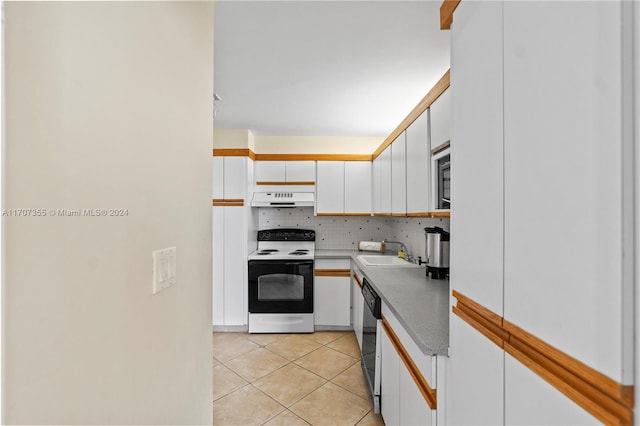 5005 Collins Ave Unit 425, Miami Beach, FL 33140 - kitchen featuring electric stove, under cabinet range hood, white cabinets, backsplash, and light tile patterned floors