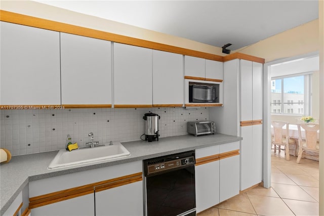 kitchen featuring sink, backsplash, white cabinetry, and black appliances