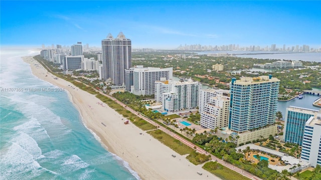 bird's eye view with a water view and a beach view