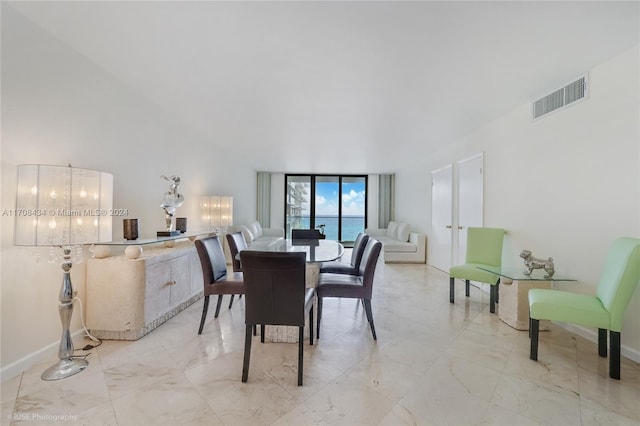 dining space with french doors and a water view