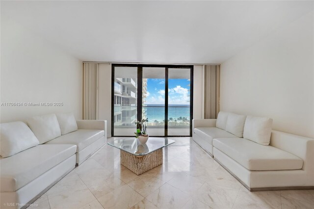 living room featuring a water view and a wall of windows