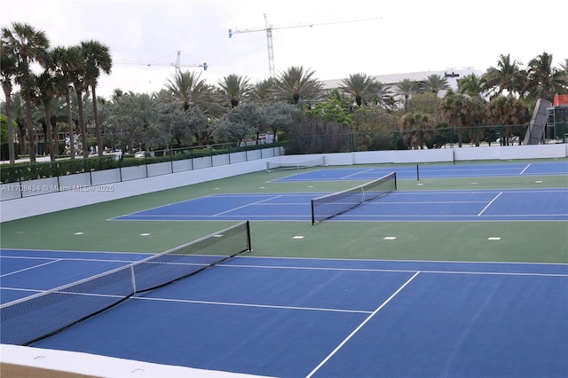 view of tennis court with community basketball court and fence