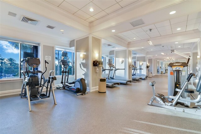 workout area featuring a paneled ceiling and crown molding