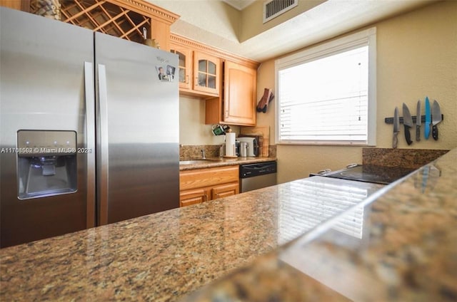 kitchen with light brown cabinets, light stone counters, and appliances with stainless steel finishes