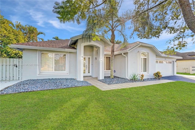 view of front of house featuring a garage and a front lawn