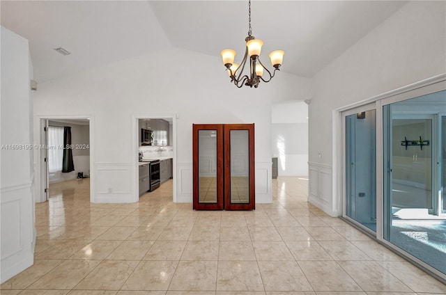 tiled spare room with high vaulted ceiling and an inviting chandelier