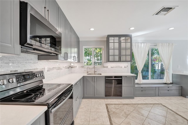 kitchen featuring appliances with stainless steel finishes, gray cabinets, light tile patterned floors, and sink