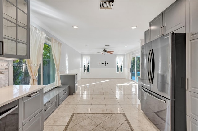 kitchen featuring gray cabinets, stainless steel fridge, ceiling fan, and light tile patterned flooring