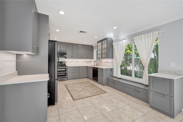 kitchen featuring gray cabinets, light tile patterned floors, sink, and appliances with stainless steel finishes