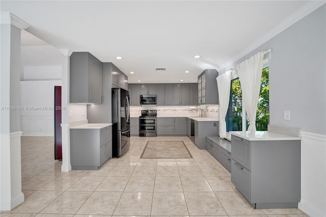 kitchen featuring appliances with stainless steel finishes, backsplash, sink, gray cabinets, and light tile patterned flooring