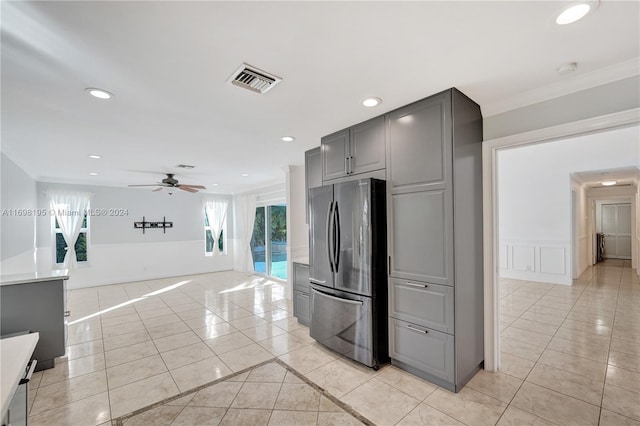 kitchen featuring stainless steel fridge, ceiling fan, crown molding, gray cabinets, and light tile patterned flooring