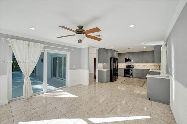 kitchen with appliances with stainless steel finishes, backsplash, gray cabinetry, ceiling fan, and sink