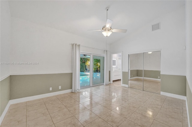 tiled spare room with high vaulted ceiling and ceiling fan