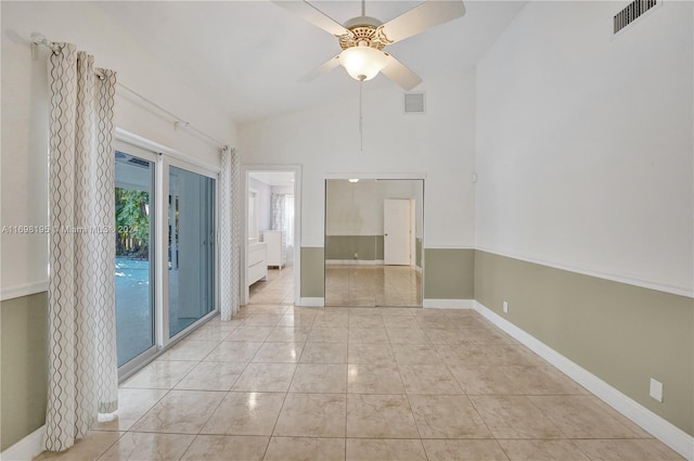 tiled spare room featuring ceiling fan and high vaulted ceiling