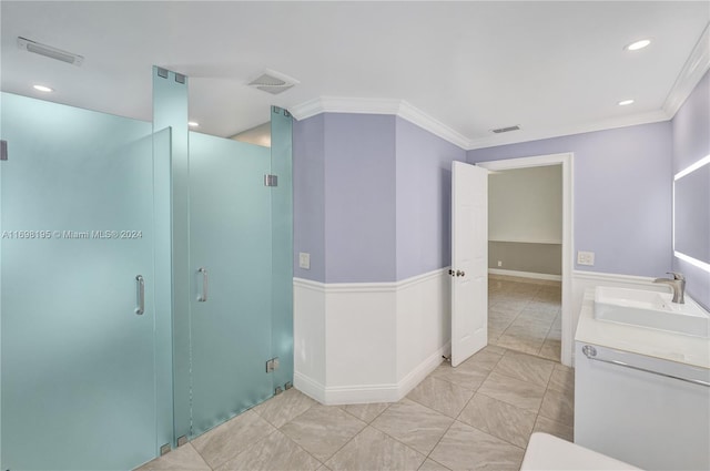 bathroom with vanity, a shower with door, and ornamental molding