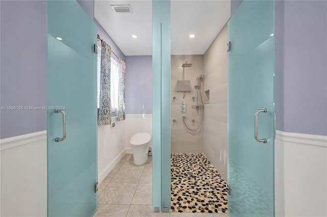 bathroom featuring tile patterned flooring, toilet, and an enclosed shower