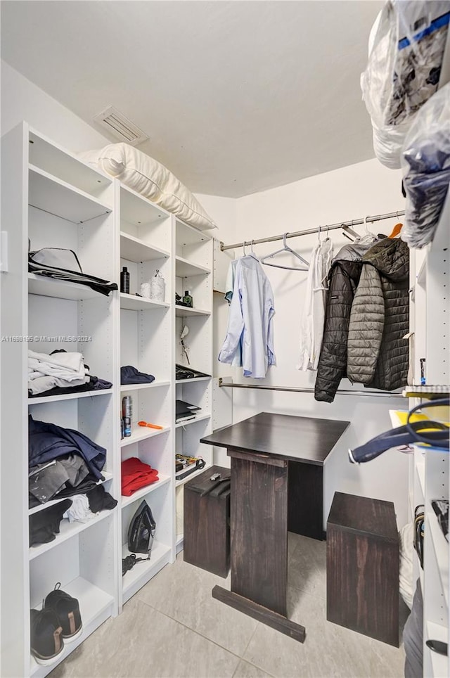 walk in closet with light tile patterned floors