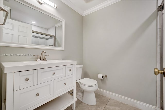 bathroom with tile patterned floors, toilet, vanity, a shower with shower door, and ornamental molding