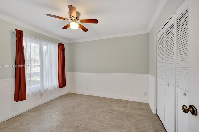 unfurnished bedroom featuring ceiling fan, ornamental molding, light tile patterned floors, and a closet