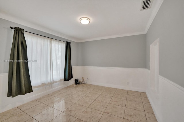 empty room featuring light tile patterned floors and ornamental molding