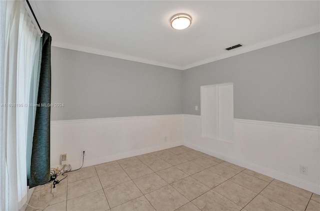 tiled empty room featuring crown molding