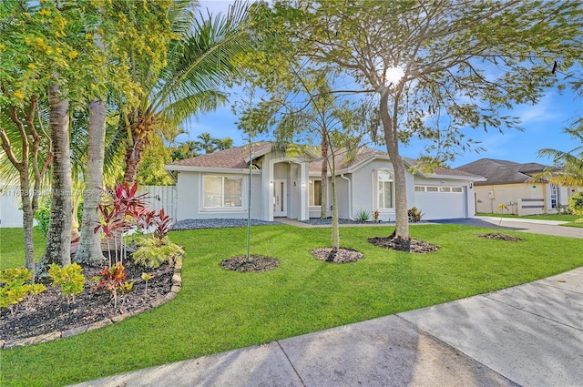 single story home featuring a front yard and a garage