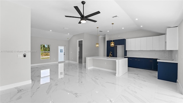 kitchen with blue cabinetry, a center island with sink, white cabinets, and vaulted ceiling