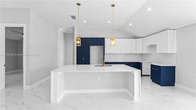 kitchen featuring a center island with sink, white cabinets, decorative light fixtures, and vaulted ceiling