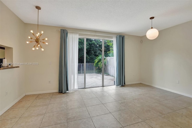 tiled spare room featuring an inviting chandelier and a textured ceiling