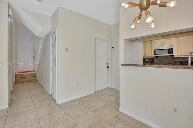 kitchen featuring an inviting chandelier, light tile patterned flooring, and decorative backsplash