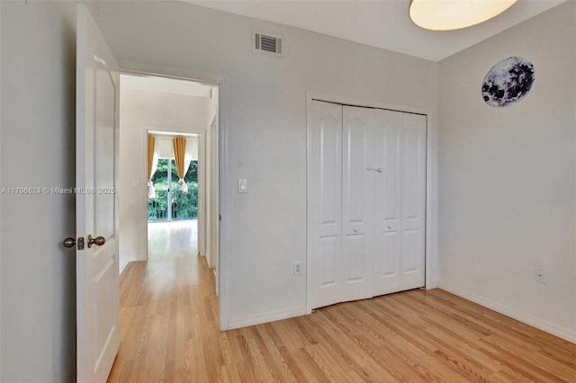 unfurnished bedroom featuring a closet and light hardwood / wood-style flooring