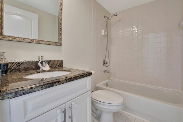 full bathroom featuring toilet, vanity, tiled shower / bath combo, and tile patterned floors