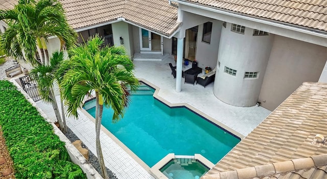 view of swimming pool featuring an in ground hot tub and a patio