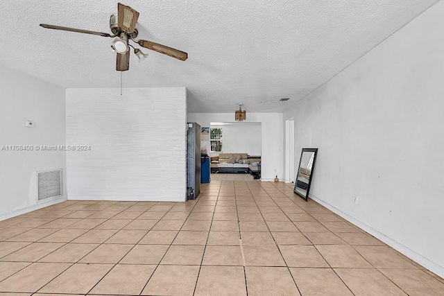 tiled spare room featuring ceiling fan and a textured ceiling