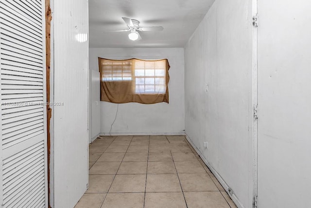 empty room with ceiling fan and light tile patterned flooring