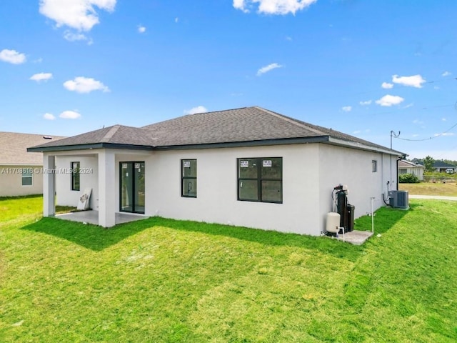 back of property featuring a lawn, a patio area, and central air condition unit