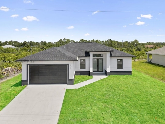 view of front of property featuring a front yard and a garage