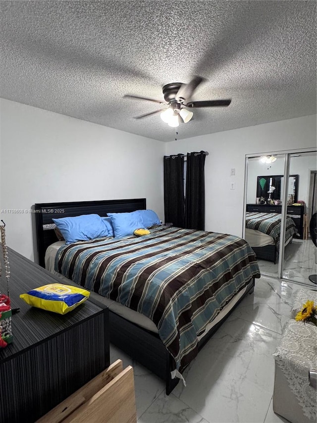 bedroom with marble finish floor, ceiling fan, and a textured ceiling