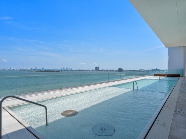 view of swimming pool featuring a water view