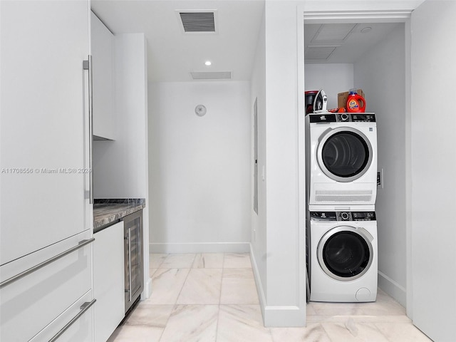 laundry area featuring stacked washer / dryer and wine cooler