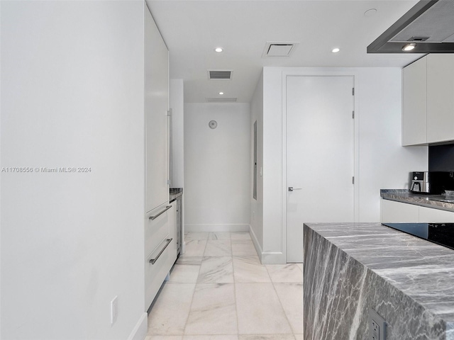 kitchen with white cabinetry and range hood