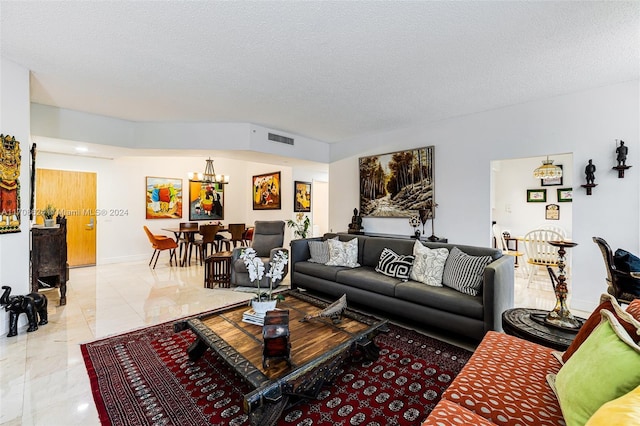 living room with a textured ceiling and a notable chandelier